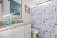 bathroom featuring a shower with curtain, vanity, and toilet