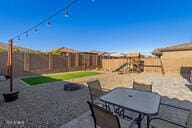 view of patio / terrace with a fenced backyard, a grill, outdoor dining area, and a playground