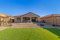 back of house with a lawn and a playground