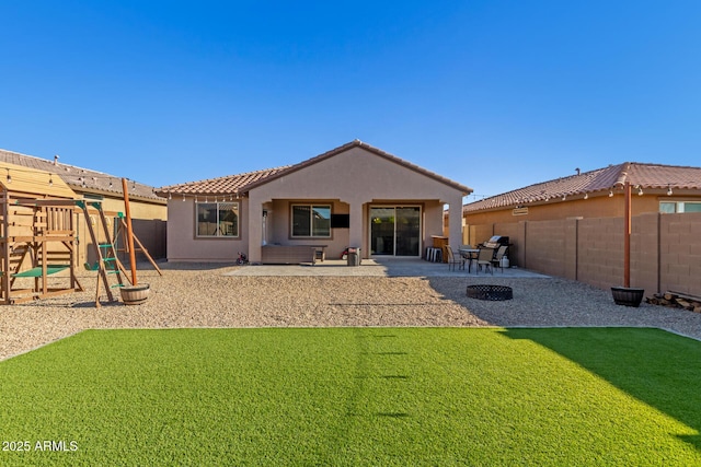 rear view of property featuring a patio area, a fenced backyard, a tile roof, and stucco siding