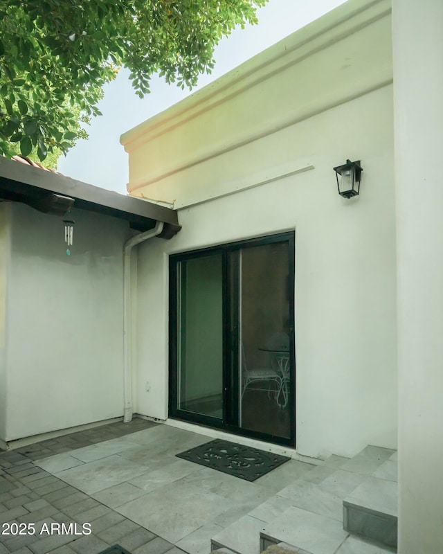 entrance to property with a patio area and stucco siding