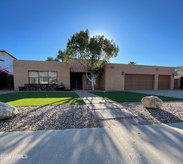 view of front of house with a front yard and a garage