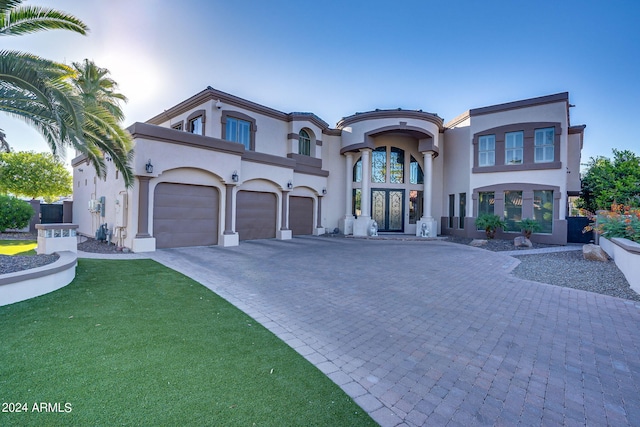 view of front of home with french doors, a front yard, and a garage