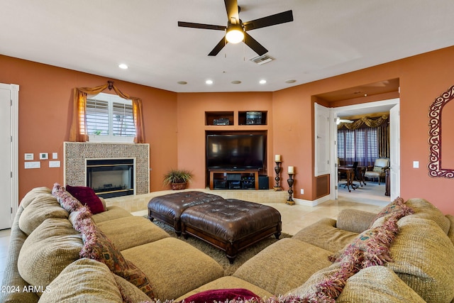 tiled living room with a tile fireplace and ceiling fan