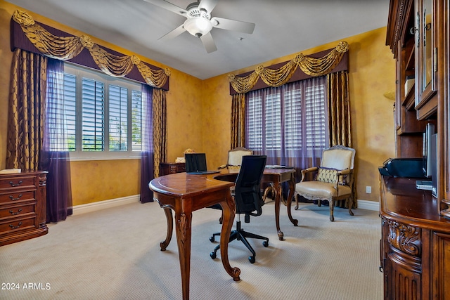 carpeted office space featuring ceiling fan