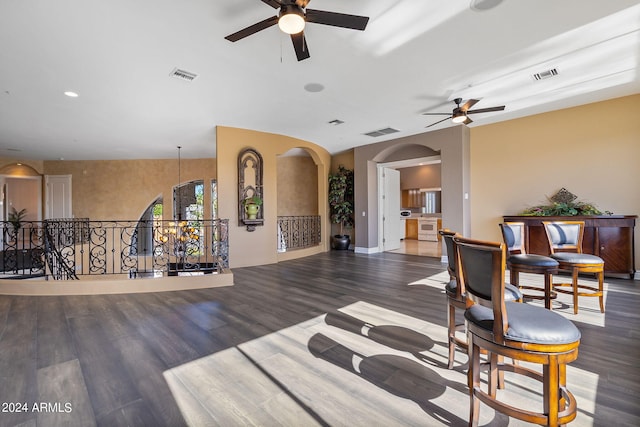 sitting room with ceiling fan and dark wood-type flooring