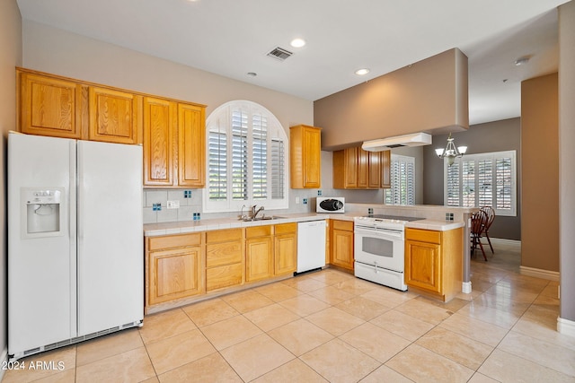 kitchen featuring white appliances, an inviting chandelier, hanging light fixtures, light tile patterned flooring, and kitchen peninsula