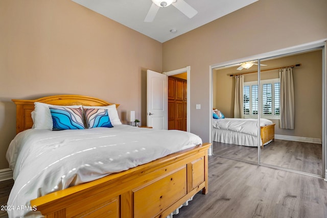 bedroom with light wood-type flooring, a closet, vaulted ceiling, and ceiling fan