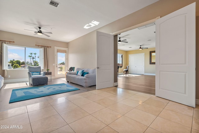 unfurnished living room with ceiling fan and light tile patterned floors