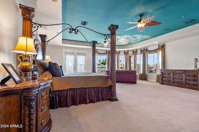 carpeted bedroom with a tray ceiling and ceiling fan