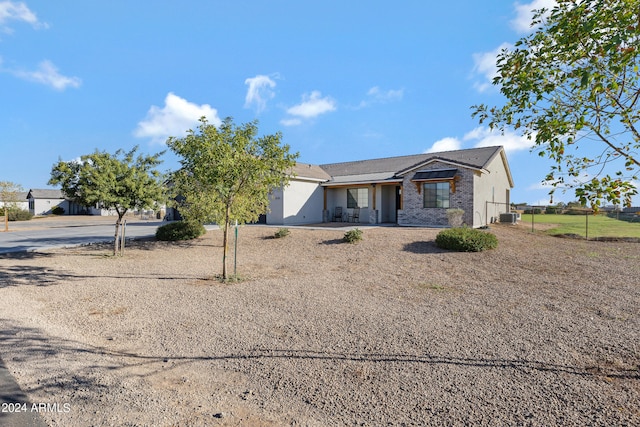 view of front of property with central AC, brick siding, and fence