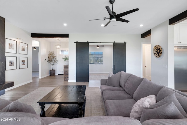 living room featuring a barn door, recessed lighting, dark wood-style flooring, a ceiling fan, and baseboards