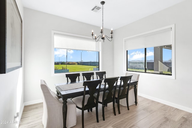 dining area with an inviting chandelier and light hardwood / wood-style flooring