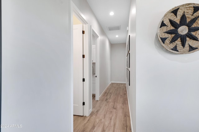 corridor with light wood finished floors, visible vents, baseboards, and recessed lighting