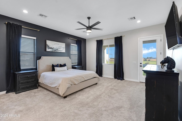 bedroom with access to outside, multiple windows, light colored carpet, and ceiling fan