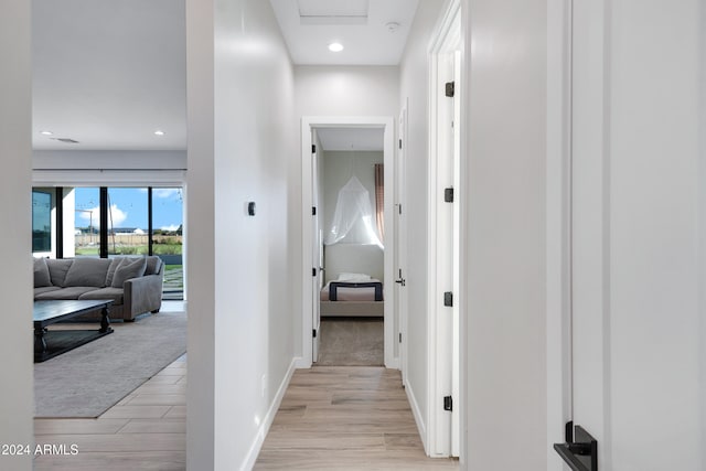 corridor with recessed lighting, light wood-style flooring, and baseboards