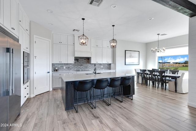 kitchen with a notable chandelier, visible vents, white cabinets, and light countertops