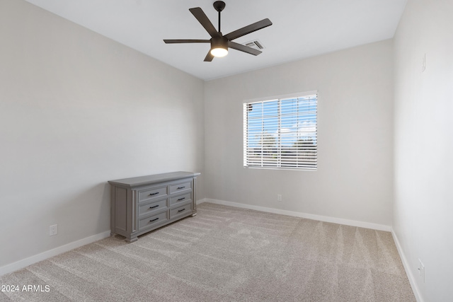 carpeted spare room featuring ceiling fan