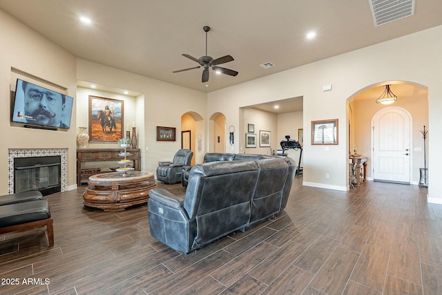 living area featuring wood tiled floor, visible vents, a fireplace, and baseboards