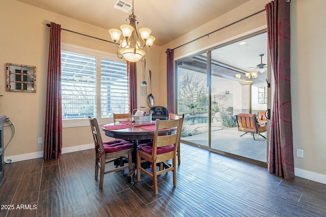 dining room with baseboards, visible vents, dark wood finished floors, and ceiling fan with notable chandelier