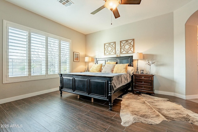 bedroom featuring arched walkways, baseboards, visible vents, and wood tiled floor