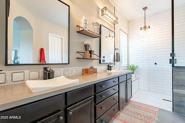 full bathroom featuring a walk in shower, double vanity, a sink, and decorative backsplash