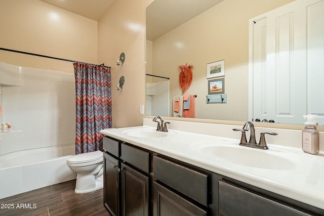 bathroom with double vanity, wood finished floors, a sink, and toilet