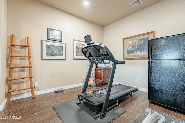 workout room with baseboards, visible vents, and wood tiled floor