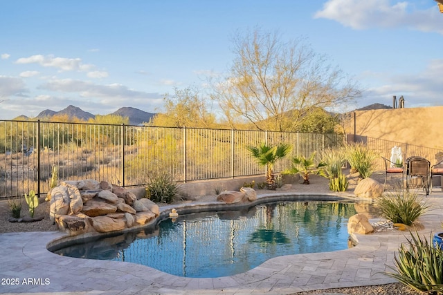 view of pool with a fenced in pool, a fenced backyard, a mountain view, and a patio