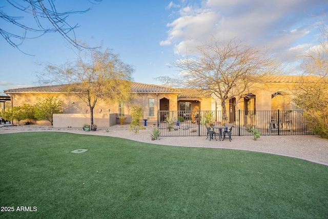 back of property with a patio, stucco siding, a lawn, fence, and a tiled roof