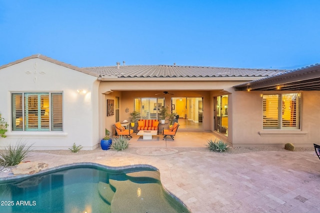 back of property with a patio, a tile roof, ceiling fan, an outdoor living space, and stucco siding