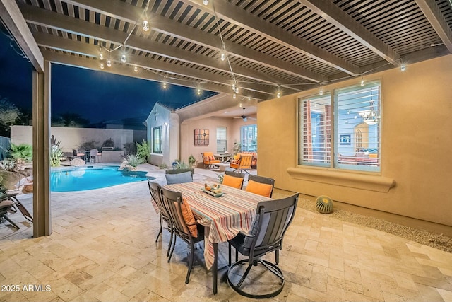 interior space featuring track lighting, beam ceiling, and stone tile flooring