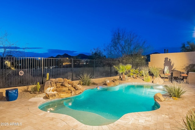 view of pool with a fenced backyard, a mountain view, a fenced in pool, and a patio