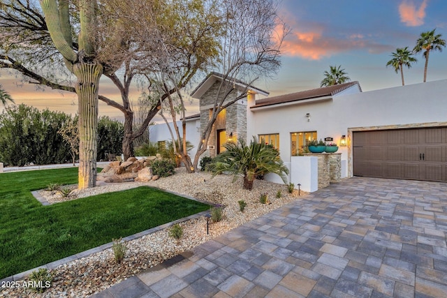 view of front of property featuring a garage and a lawn