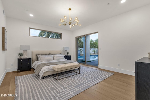 bedroom with hardwood / wood-style flooring, access to exterior, and a notable chandelier