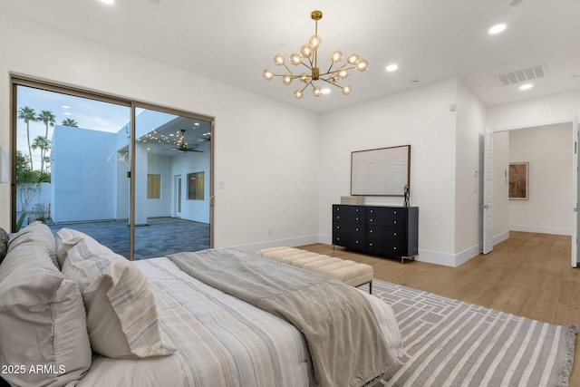 bedroom featuring access to exterior, a notable chandelier, and wood-type flooring