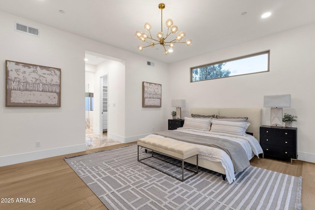 bedroom with hardwood / wood-style flooring and an inviting chandelier