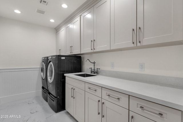 laundry room featuring cabinets, sink, and washing machine and dryer