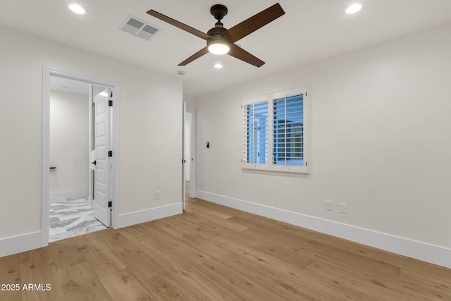 unfurnished bedroom with ensuite bathroom and light wood-type flooring