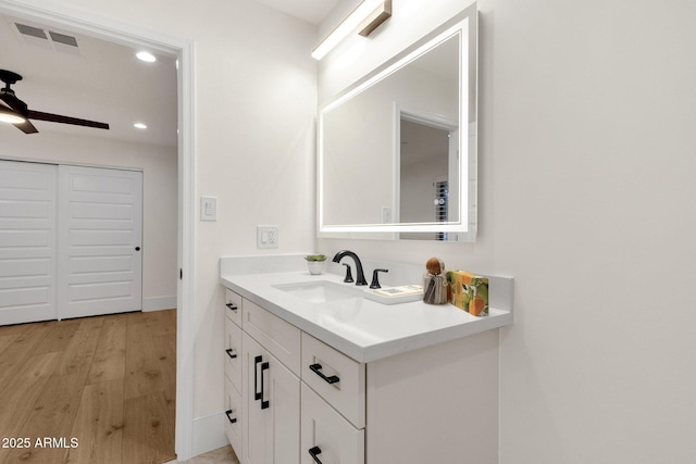 bathroom with ceiling fan, vanity, and wood-type flooring