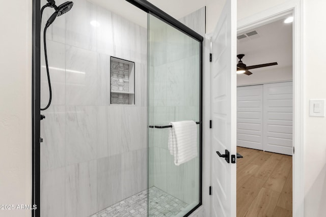 bathroom featuring wood-type flooring, ceiling fan, and walk in shower