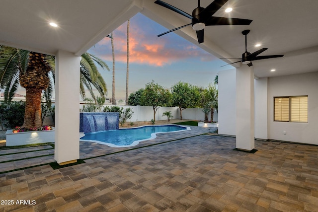 pool at dusk with a patio area