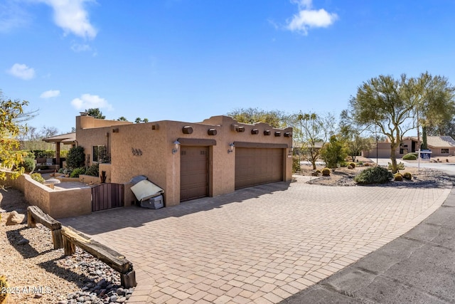 view of front of property with a garage, decorative driveway, and stucco siding