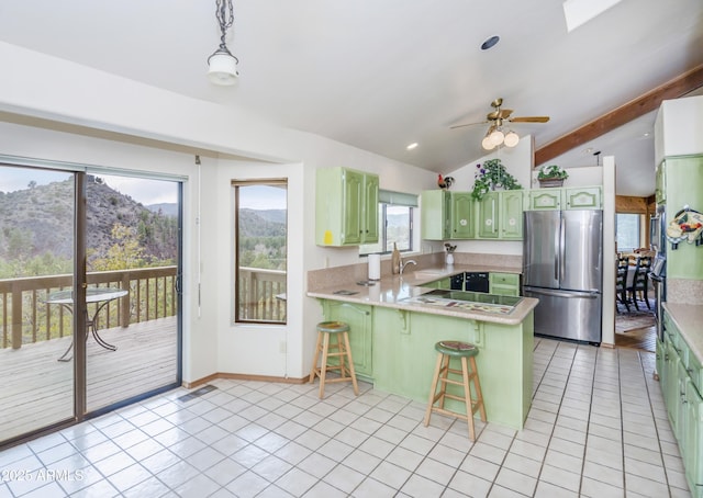 125 Partridge Ln, Prescott, AZ 86303 - kitchen featuring freestanding refrigerator, light tile patterned floors, green cabinets, a peninsula, and a breakfast bar