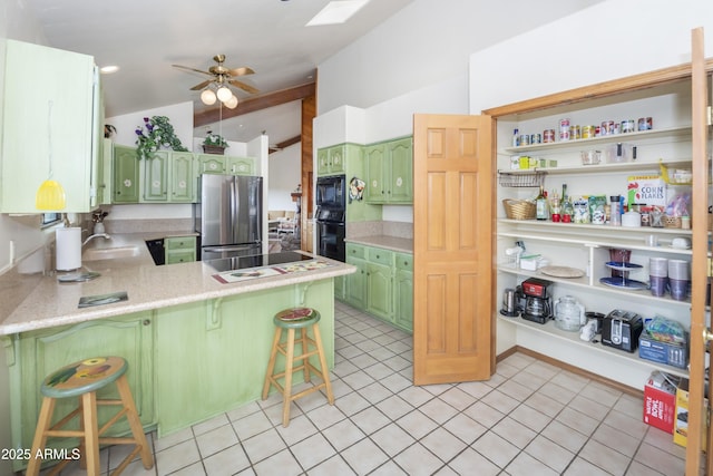 125 Partridge Ln, Prescott, AZ 86303 - kitchen featuring green cabinets, a peninsula, vaulted ceiling, black appliances, and light countertops