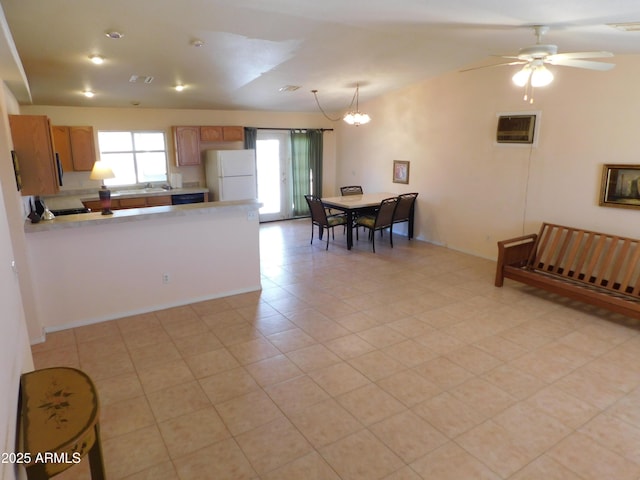 kitchen featuring visible vents, lofted ceiling, freestanding refrigerator, light countertops, and ceiling fan with notable chandelier