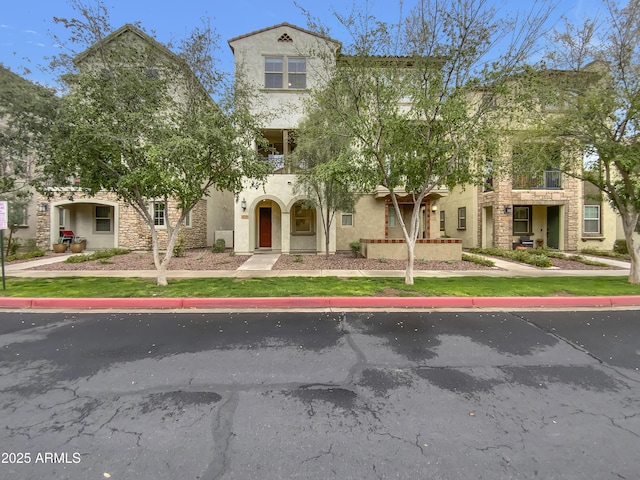 view of front of home featuring stone siding and stucco siding