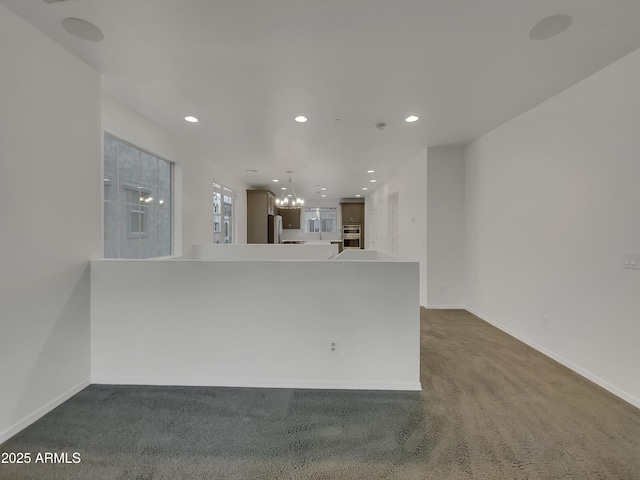 interior space featuring recessed lighting, baseboards, and a chandelier