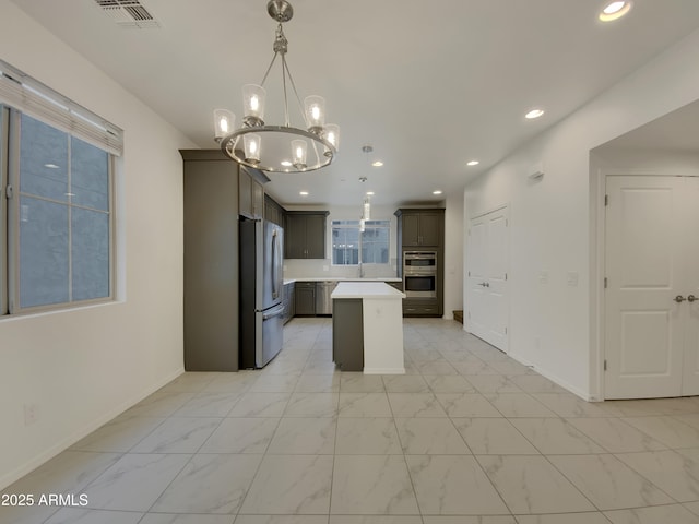 kitchen with visible vents, marble finish floor, a sink, stainless steel appliances, and light countertops