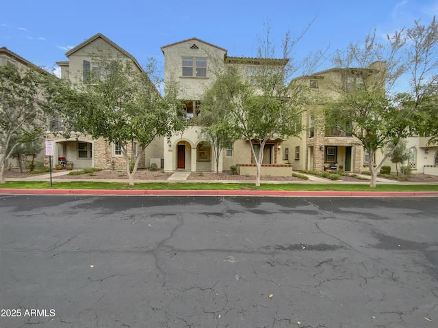 mediterranean / spanish-style home with stone siding